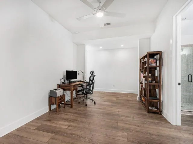 a view of a workspace with furniture and wooden floor