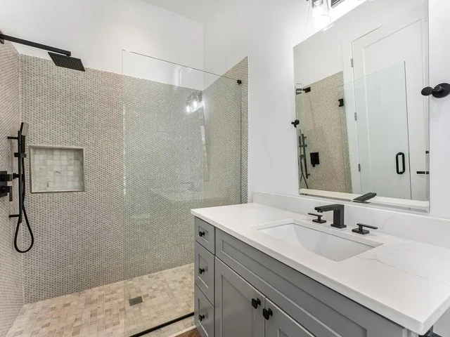 a bathroom with a sink mirror and a shower