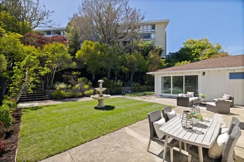 a view of a house with backyard sitting area and garden