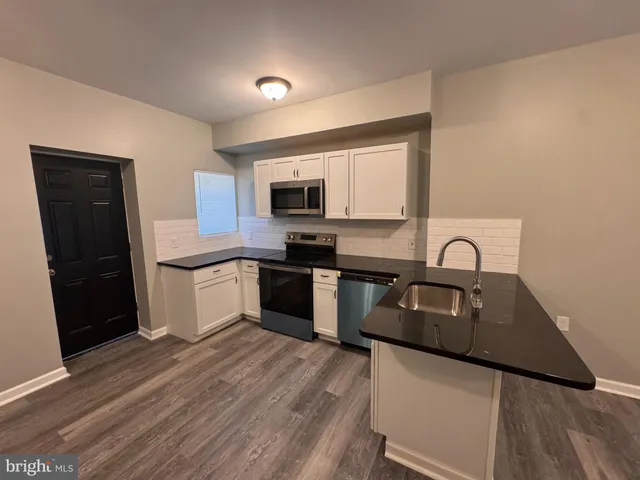 a kitchen with a sink a stove a microwave and refrigerator