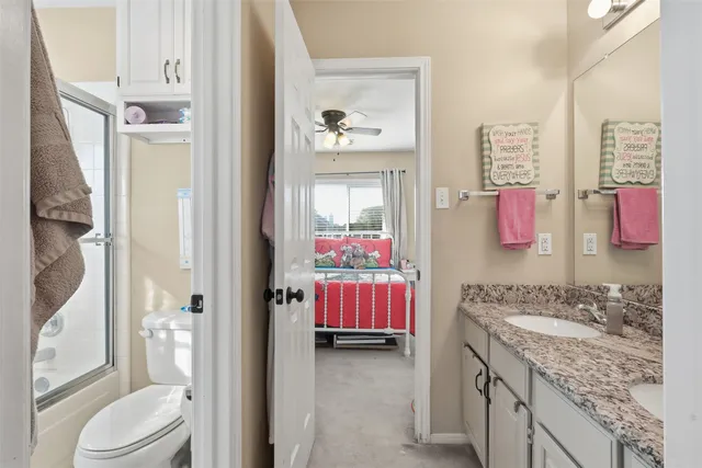 a en suite bathroom with a granite countertop sink and a mirror