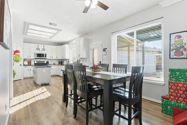 a kitchen with stainless steel appliances kitchen island granite countertop a dining table chairs and granite counter tops