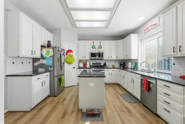 a kitchen with stainless steel appliances granite countertop a stove sink and cabinets
