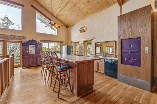 a dining hall with stainless steel appliances granite countertop a stove and wooden floors