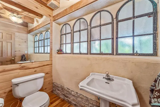 a bathroom with a sink and mirror with toilet