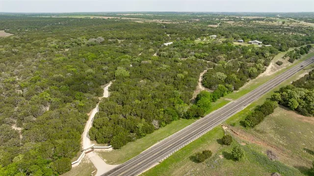 an aerial view of residential houses with outdoor space and trees