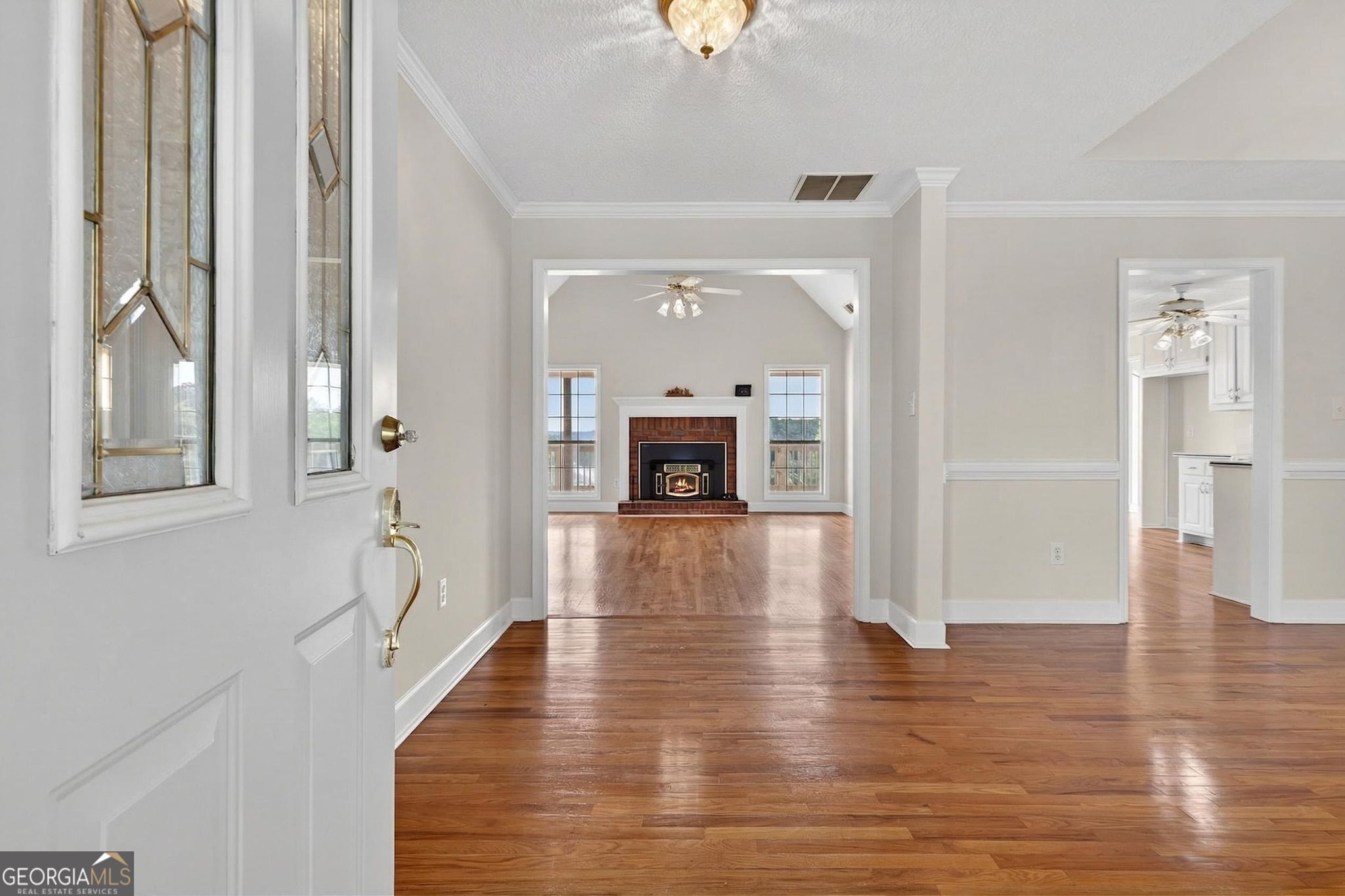 955 Mocassin Gap Road Locust Grove, GA 30248 - Photo 5 of 59 a hallway with wooden floor fireplace and windows