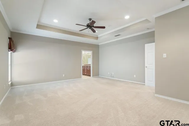 an empty room with a ceiling fan and window