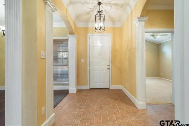 a view of a hallway with wooden floor and a bathroom
