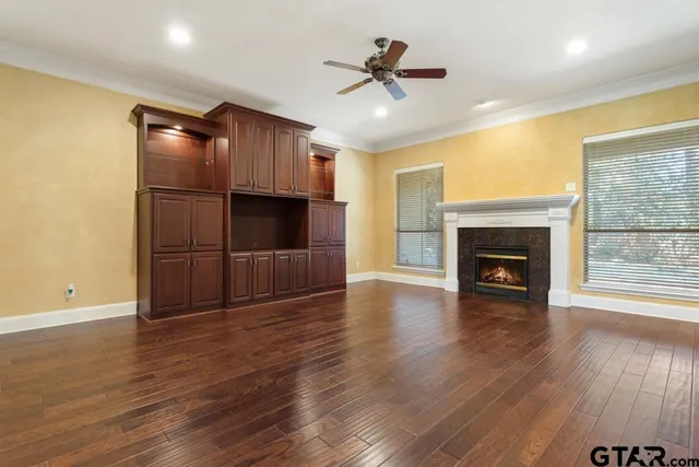 a view of empty room with wooden floor and fireplace