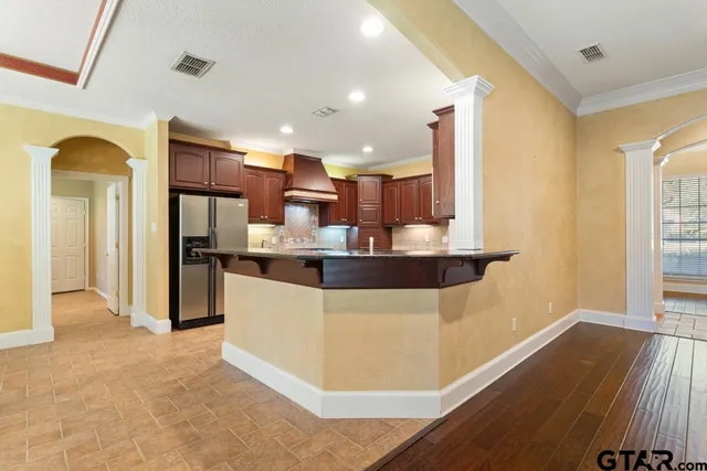 a kitchen with stainless steel appliances kitchen island granite countertop a refrigerator and a stove