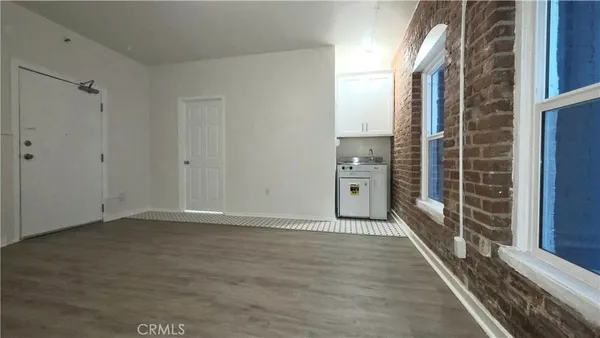a view of a hallway with wooden floor and a living room