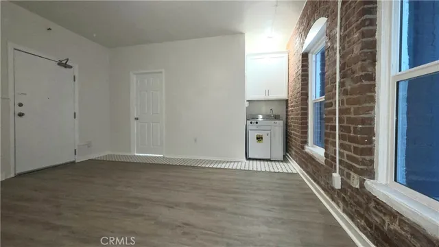 a view of a hallway with wooden floor and a living room