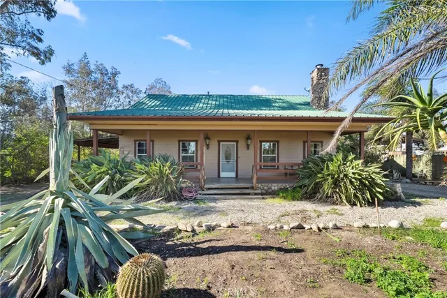 a view of a house with small yard and a large tree