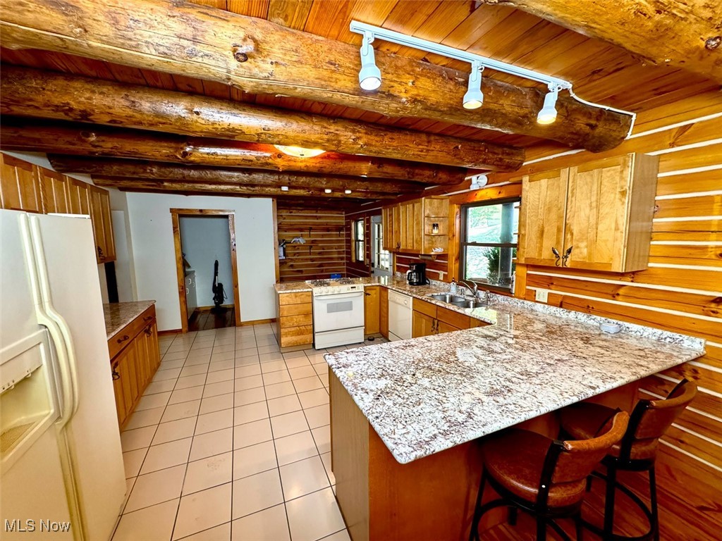 18063 Sligo Road Freeport, OH 43973 - Photo 35 of 50 Kitchen featuring a peninsula, white appliances, rail lighting, a breakfast bar area, and a wooden ceiling with exposed beams