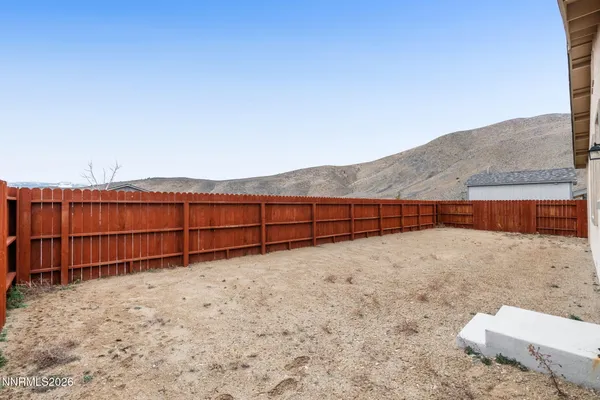 a view of backyard with wooden fence