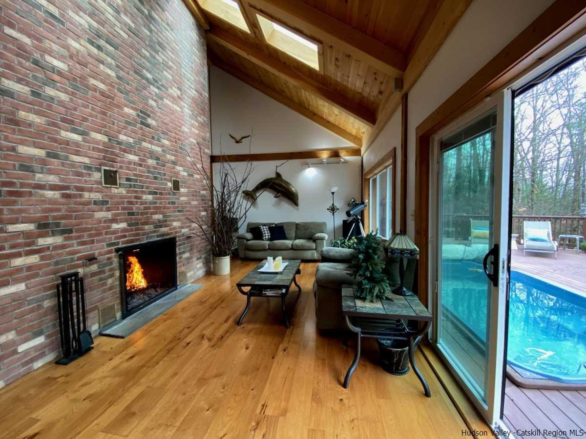 56 Ridge Road Shokan, NY 12481 - Photo 16 of 34 a living room with furniture a fireplace and a floor to ceiling window