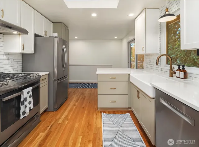 a kitchen with stainless steel appliances a stove a sink and a refrigerator