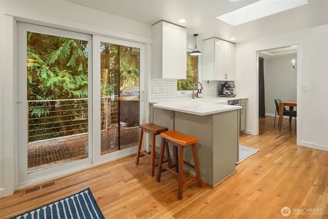 a view of kitchen with granite countertop window and wooden floor
