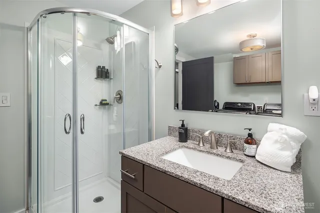 a bathroom with a granite countertop sink and a mirror
