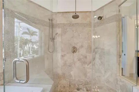 a bathroom with a granite countertop sink a mirror and shower