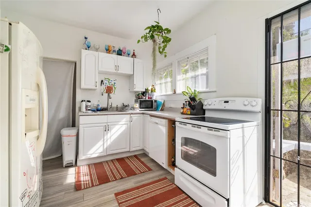 a kitchen with white cabinets and white appliances