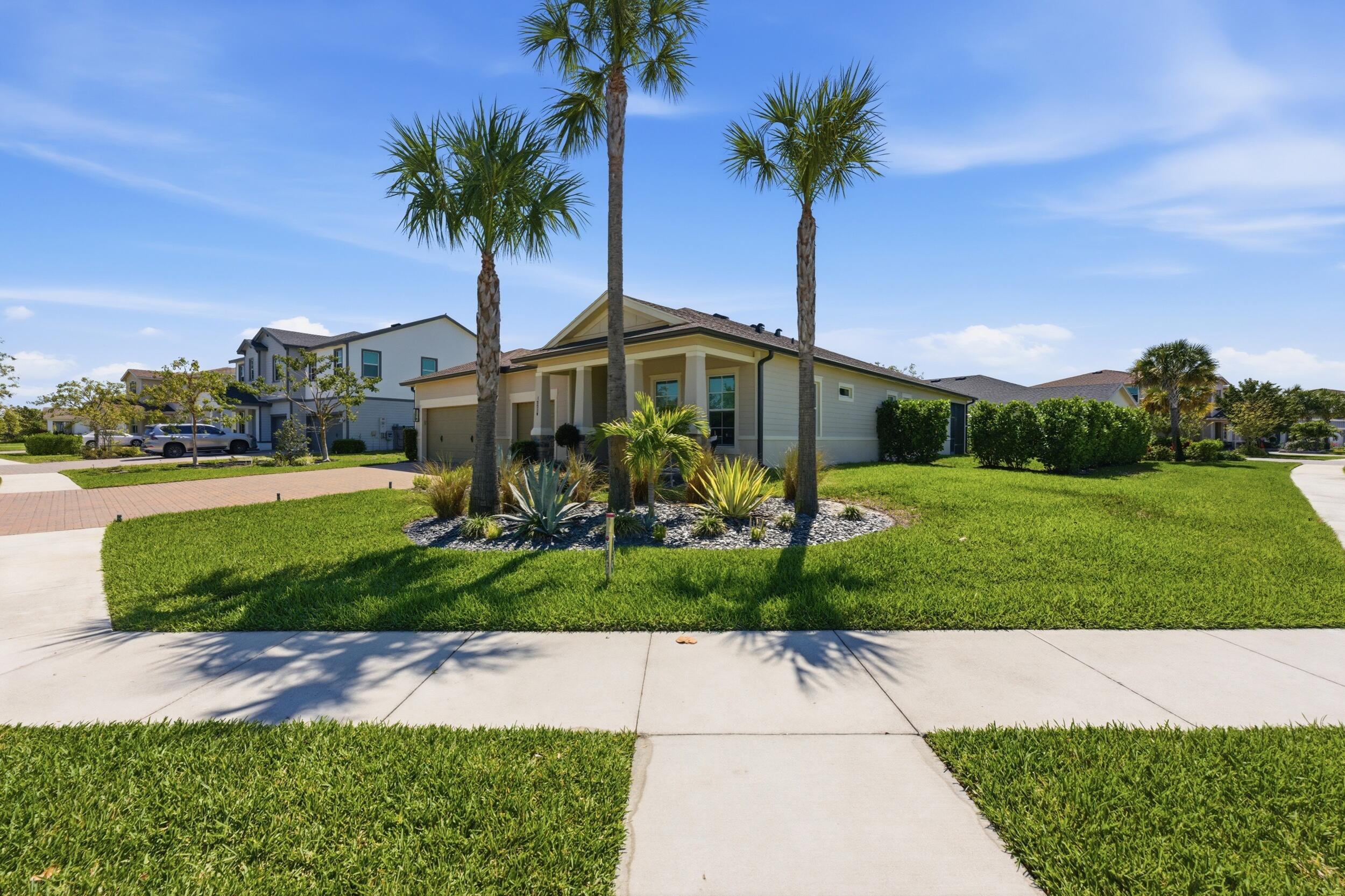 19230 Rolling Acres Road Loxahatchee, FL 33470 - Photo 43 of 58 a front view of a house with garden