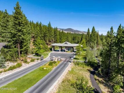 a view of a swimming pool with a yard and trees in the background