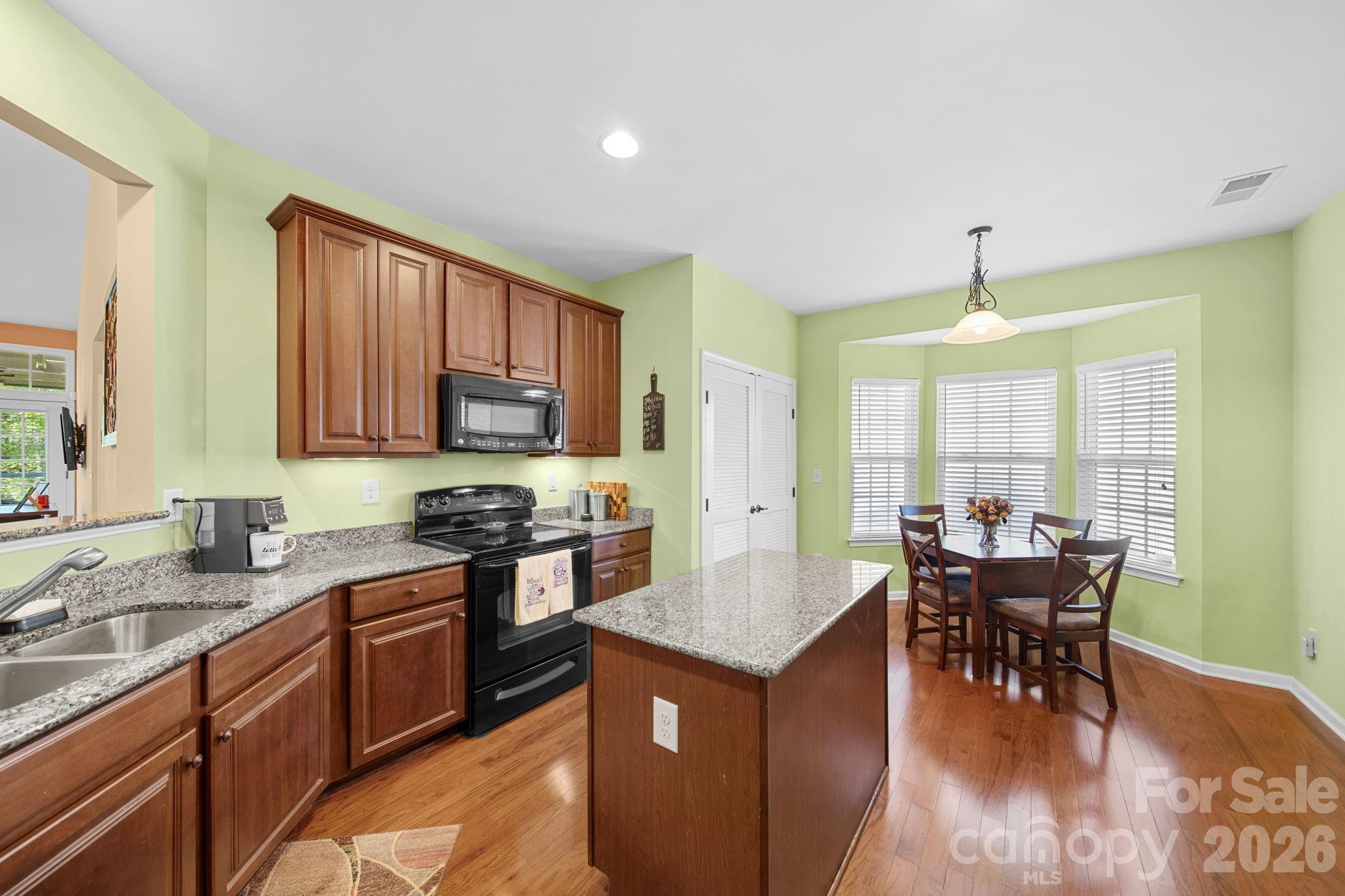 115 Inlet Point Drive Fort Mill, SC 29708 - Photo 12 of 48 a kitchen with stainless steel appliances granite countertop wooden cabinets a dining table and chairs
