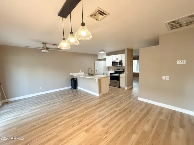 a view of a kitchen with a sink and wooden floor