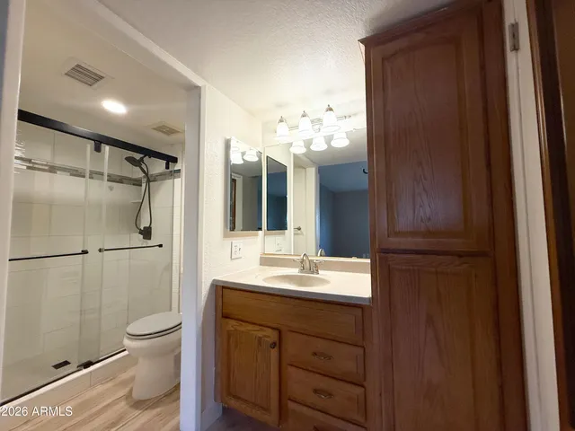 a bathroom with a double vanity sink toilet and shower