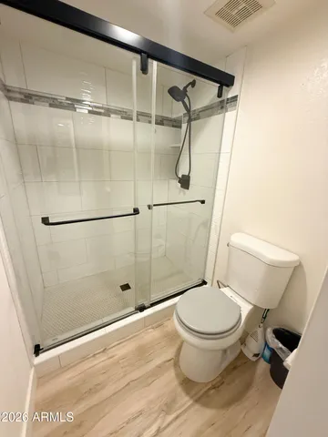 a white toilet sitting next to a shower