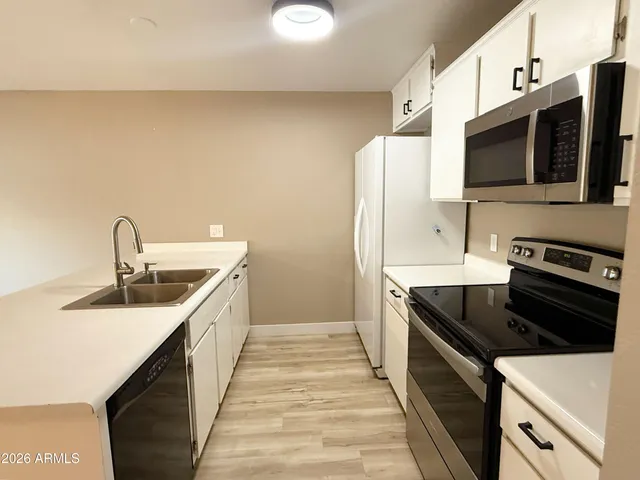 a kitchen with stainless steel appliances a sink stove and microwave