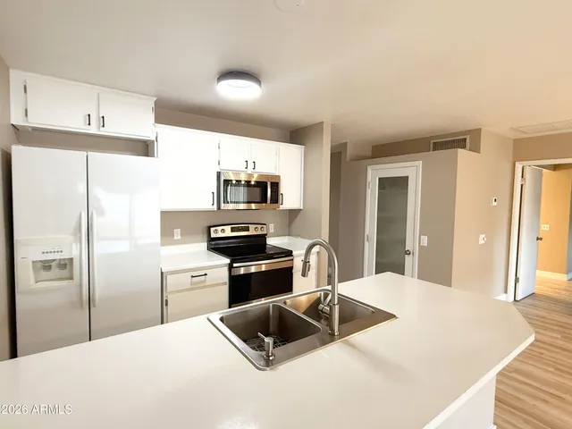 a kitchen with stainless steel appliances a refrigerator sink and stove