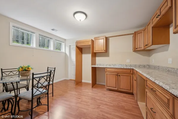a kitchen with granite countertop chair and wooden cabinets
