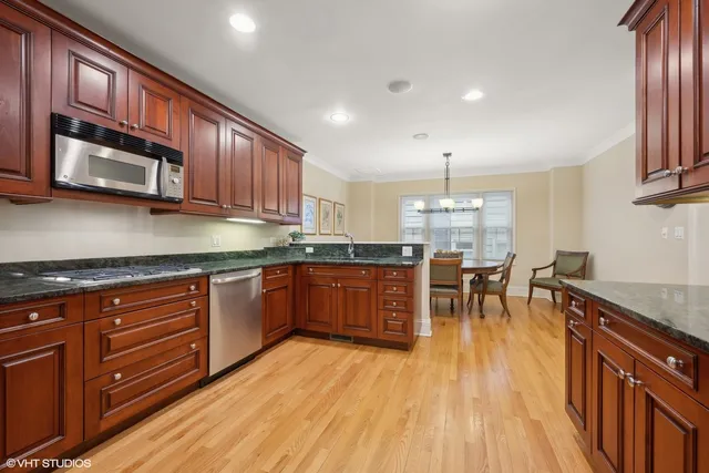 a kitchen with stainless steel appliances granite countertop wooden floors stove top oven a sink with granite countertops and cabinets