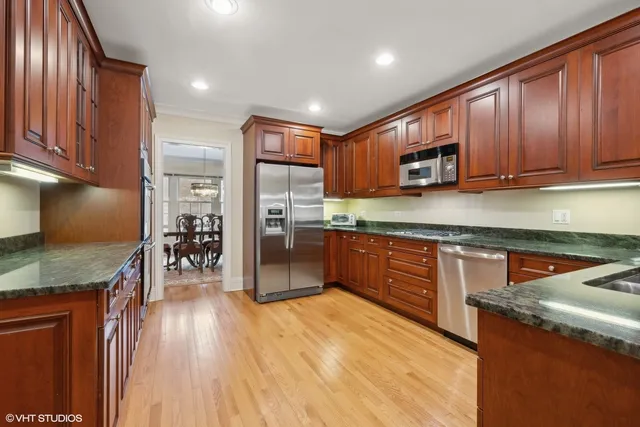 a kitchen with stainless steel appliances granite countertop wooden cabinets a stove top oven a sink and dishwasher