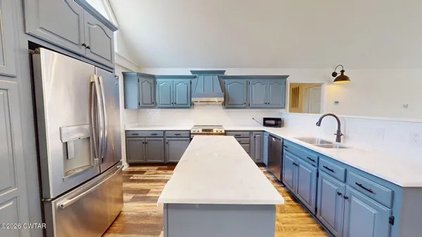 a kitchen with granite countertop a refrigerator stove and sink