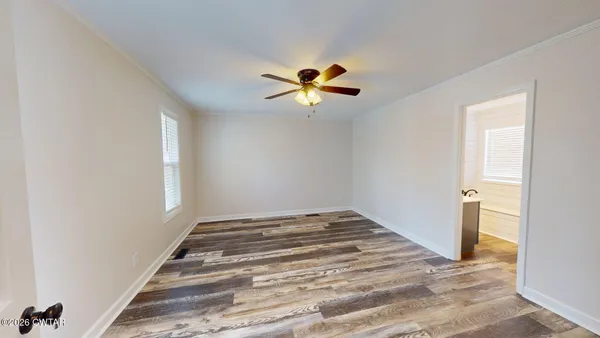 a room that has a bed and a chandelier fan