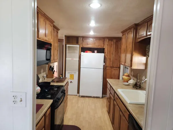 a kitchen with a refrigerator and a stove top oven