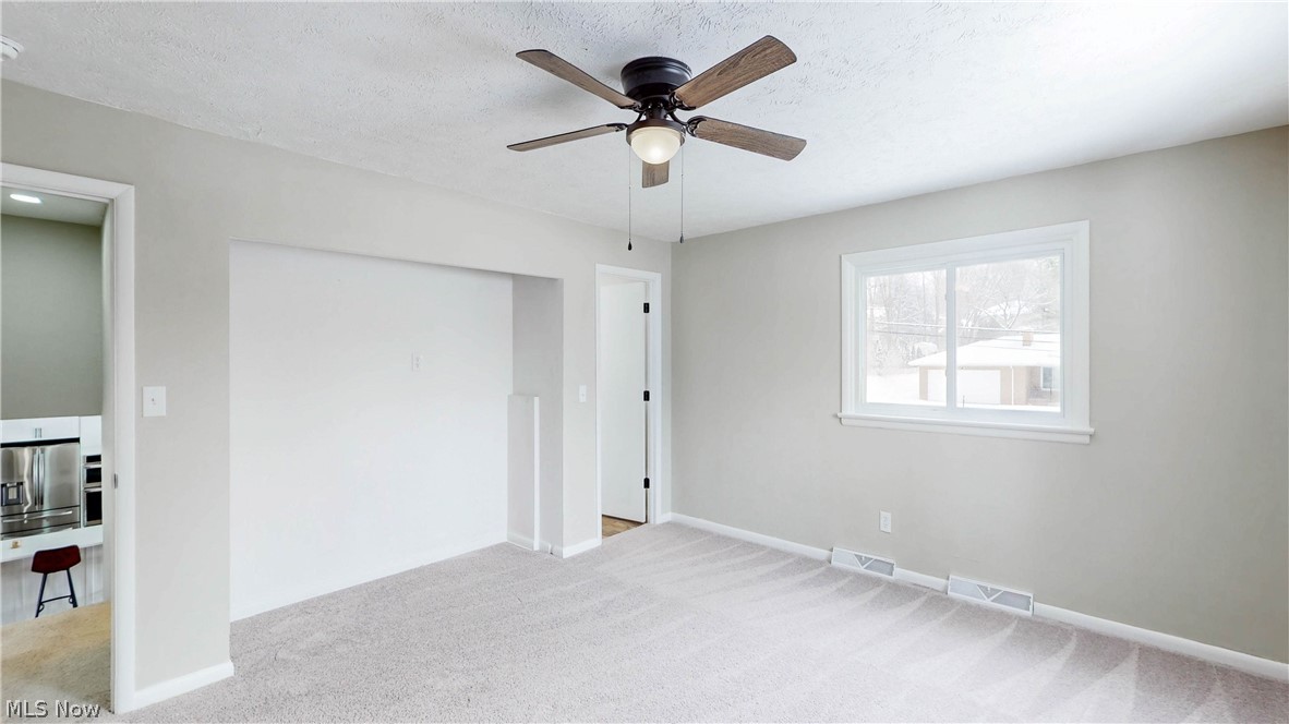 3312 Bancroft Road Akron, OH 44333 - Photo 34 of 50 Unfurnished bedroom with light colored carpet, stainless steel fridge with ice dispenser, a ceiling fan, and a textured ceiling