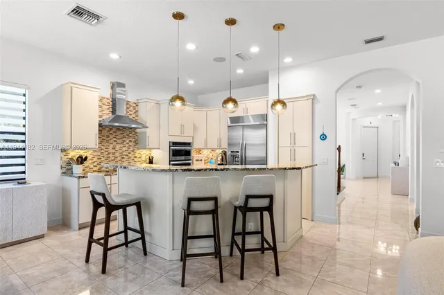 a kitchen with stainless steel appliances granite countertop a stove a sink and a refrigerator