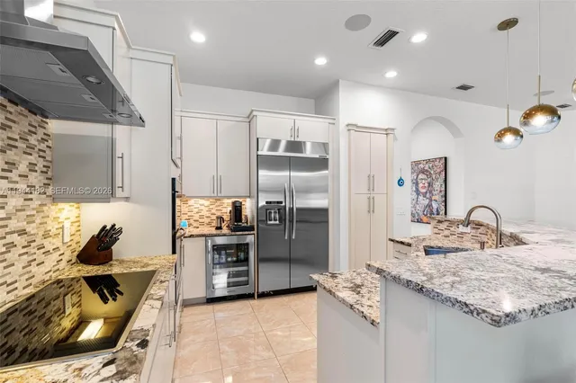 a kitchen with kitchen island a counter top space appliances and a center island