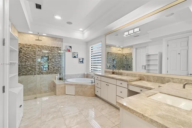 a large bathroom with a large mirror vanity and shower