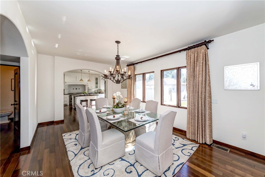 950 Old Mill Road Pasadena, CA 91108 - Photo 12 of 42 a dining room with wooden floor a chandelier a wooden table and chairs