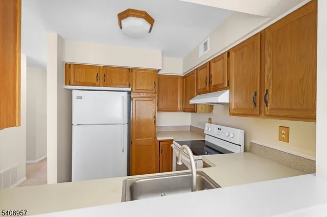 a kitchen with a refrigerator a stove and a cabinets