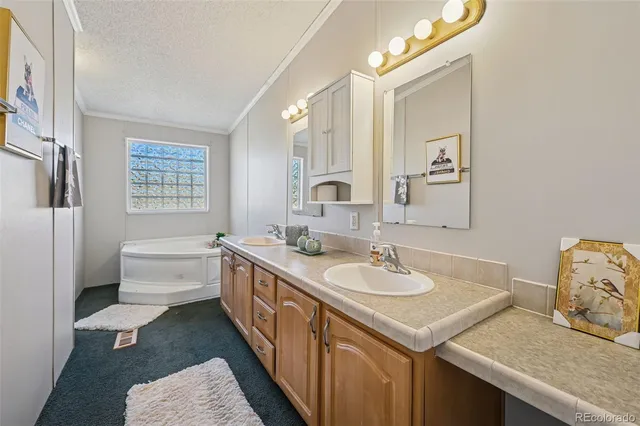 a view of a dining room and livingroom with furniture wooden floor a rug a painting and a chandelier
