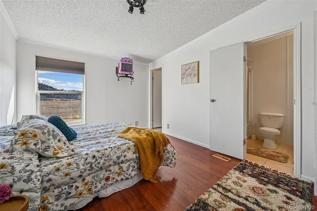 a bedroom with a bed and painting on the wall