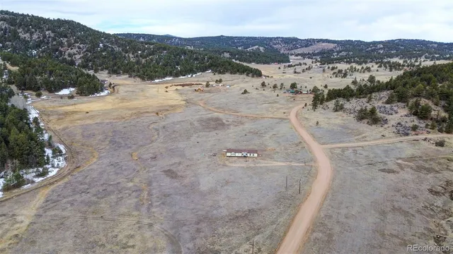 a view of a dry field with mountains in the background