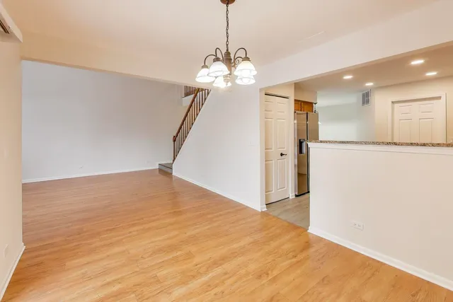 a view of a room with wooden floor and chandelier